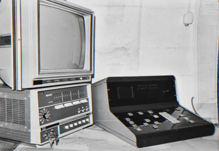 An early ETEP system: a monitor on an equipment unit, next to a sloped keyboard console